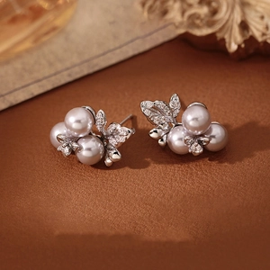 Detail of elegant silver needle earrings with grey cluster pearls and rhinestones