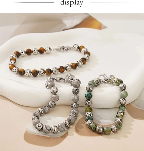 Detailed macro of tiger eye and marble bead bracelets with silver-tone lobster clasp