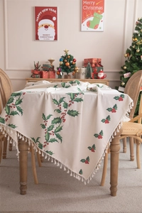 Detail of Christmas tablecloth with holly berry print and elegant beige fringe edges