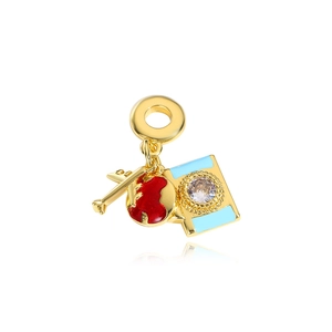 Macro shot of gold charm with a red heart key and blue book pendant on white background