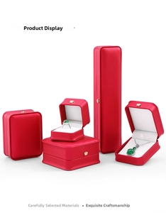 Macro view of luxury red jewelry gift boxes with gold crown and white velvet interior