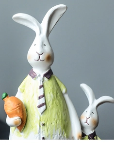 Detail of hand-painted resin rabbits figurines with carrot in American country style