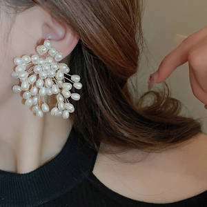 French style starburst faux pearl stud earrings with gold wire weaving on model