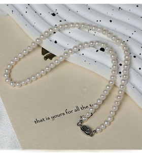 Macro shot of S925 sterling silver clasp and natural white pearls on a minimalist necklace
