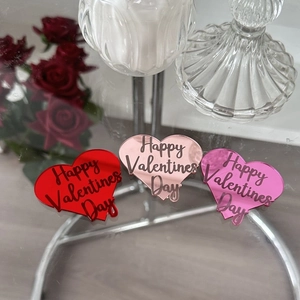 Close-up of heart-shaped acrylic cupcake toppers in red and rose gold for Valentine's Day