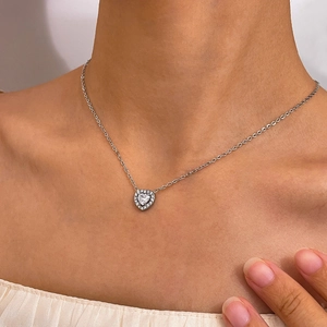 Detail of silver heart necklace featuring a large heart crystal with pavé-set stones