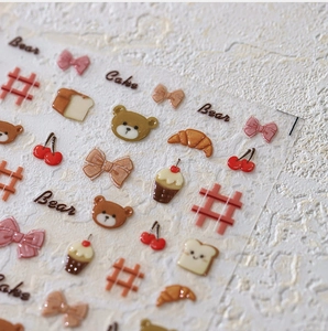 Close-up of 3D embossed cartoon nail stickers with bear and cupcake motifs