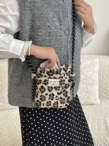 Plush leopard print crossbody bag with drawstring strap and embroidered fabric label