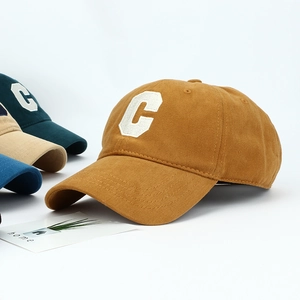 Macro view of caramel cotton baseball cap with white 3D embroidered C letter