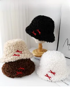 Détail de quatre bobs en peluche pour femmes en noir crème café et blanc avec nœuds