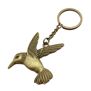 Vintage bronze hummingbird metal keychain with detailed bird pendant on white background