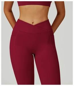 Détail du pantalon de yoga taille haute avec ceinture croisée et poches latérales bordeaux