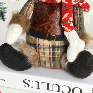 Gnomo di Natale europeo in peluche scozzese seduto su un libro bianco decorativo casa