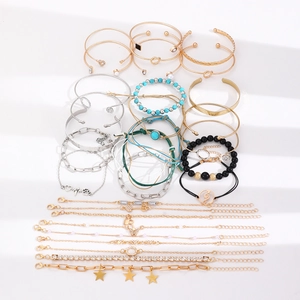 Gouden en zilveren armbandenset met hart-, ster- en knoopontwerpen op witte achtergrond