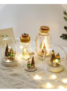 Close-up of LED glass jars with Xmas trees and miniature Santa in artificial snow
