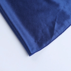 Detailed macro view of deep blue satin fabric with professional stitching and smooth texture
