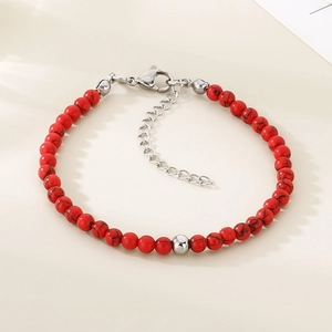 Détail de perles de pierre rouge à texture noire avec fermoir homard en acier argenté