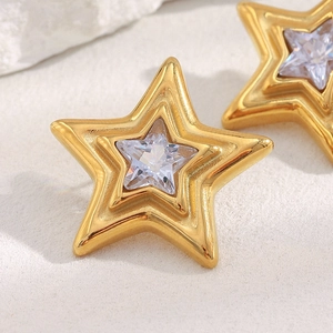 Macro shot of 18K gold plated star earrings with sparkling zircon center stone