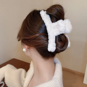 Detailed back view of a plush white faux fur claw clip holding hair in a sleek bun style