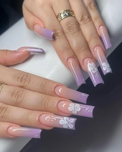 Detailed view of long square press-on nails with purple gradient and white flower art