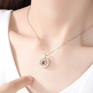 Rose gold projection necklace with circular pendant shown on a female model's neck