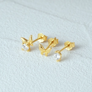 Detailed macro view of S925 sterling silver butterfly and zircon gold stud earring set