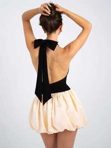 Detail des eleganten rückenfreien Designs mit großer weißer Schleife am schwarz-weißen Kleid