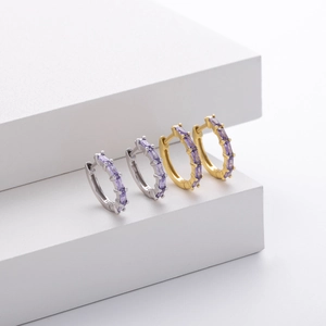 Macro detail of gold and silver S925 sterling silver earrings with purple zircon stones
