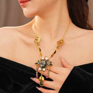 Gros plan d'un collier vintage doré avec perles et cristaux porté par un mannequin