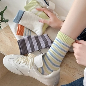 Chaussettes rayées en coton respirant de couleurs variées portées par un mannequin