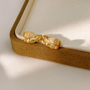 Detailed close-up of 14K gold plated serpent link earrings with shimmering zircon accents