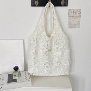 Détail du sac cabas en dentelle blanche brodée avec motifs ajourés de style chic français