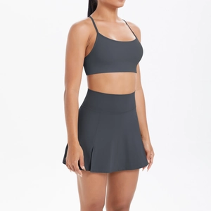 Détail de l'ensemble de yoga gris anthracite avec brassière de sport et jupe de tennis plissée