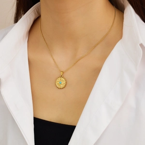 Détail du collier avec pendentif œil maléfique plaqué or 18 carats porté par un mannequin