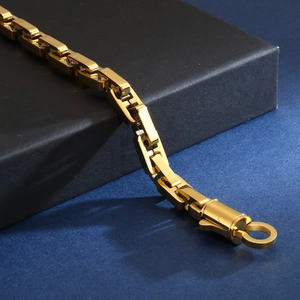 Close-up of a chunky gold stainless steel geometric link chain with a thick fold-over clasp