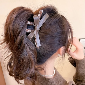 Detail of a large brown leather bow hair claw clip for high ponytail styling