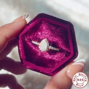 Macro shot of S925 sterling silver pear-shaped opal ring in a purple velvet hexagon box