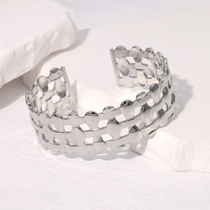 Macro detail of silver open cuff bracelet showing the layered hollow woven design texture