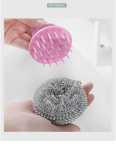 Detail showing a pink silicone kitchen brush and a steel wire scrubber with handles