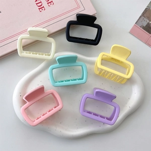 Detailed macro view of small matte square hair claws in a variety of macaron colors