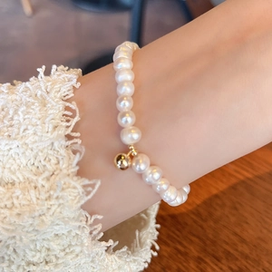 Elegant natural freshwater pearl bracelet with 14K gold bead on a model's wrist