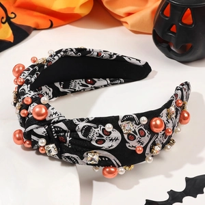 Detail of Halloween knotted headband with skull print, orange beads and rhinestones