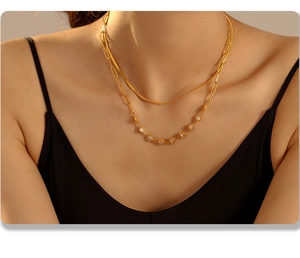 Close-up of double-layer gold snake chain and heart zircon necklace on model neckline