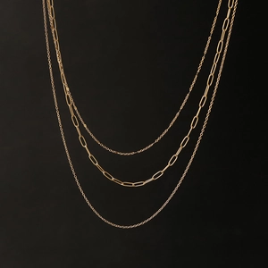 Detailed view of layered gold titanium necklace with trendy paperclip and link chains