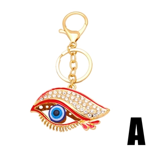 Golden Evil Eye keychain with blue bead, red enamel, and crystals on a white background