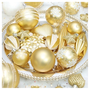 Close-up of golden Christmas ornaments including stars and hearts on a mirror tray