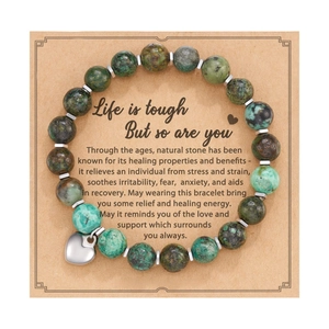 Detail of pink zebra jasper beaded heart bracelet on a kraft card with message