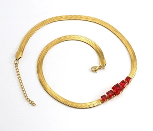 Macro view of gold snake chain necklace featuring five radiant red square crystals