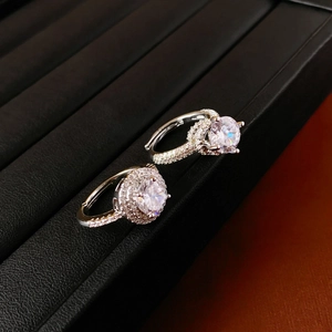 Vue macro de bagues en argent avec zircons ronds sur un support en cuir noir élégant