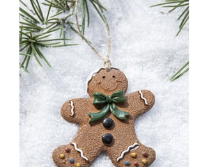 Vue détaillée du pendentif bonhomme de pain d'épices sur fond de neige et sapin vert